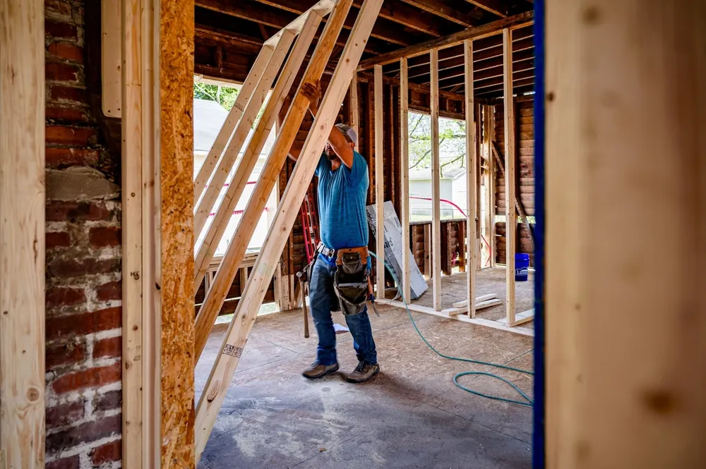 Builder working inside a wood framed home renovation