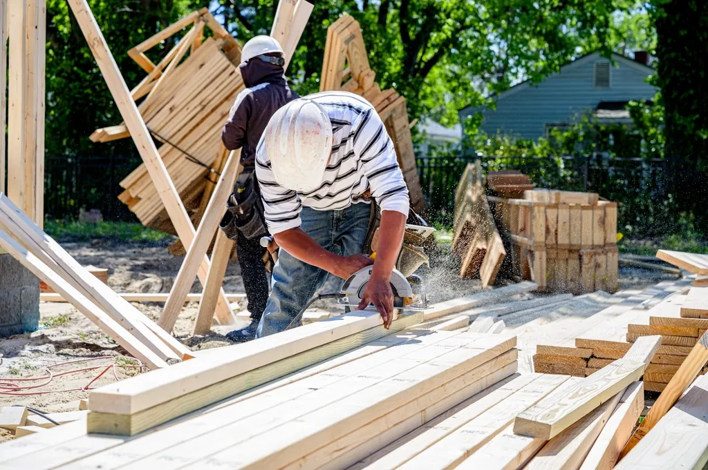 Builders cutting lumber at a residential building site